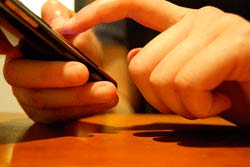 guy texting girls on his cellphone a guy types in his phone in the process of texting girls